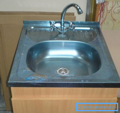 Bir kaldırım taşı ve mikser ile paslanmaz çelikten lavabo Bir kaldırım taşı ve mikser ile paslanmaz çelikten lavabo