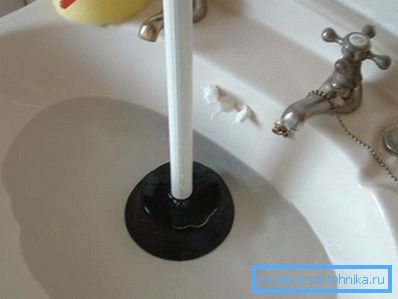 Fotoğrafta - lavabonun bir piston ile temizlenmesi Fotoğrafta - lavabonun bir piston ile temizlenmesi