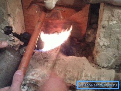 Bir blowtorch ile boru hattı bağlantılarını ısıtmak Bir blowtorch ile boru hattı bağlantılarını ısıtmak
