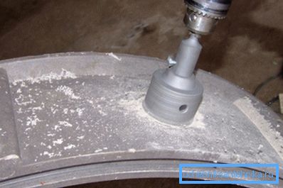 Beton halkadaki boru için bir delik açın. Beton halkadaki boru için bir delik açın.